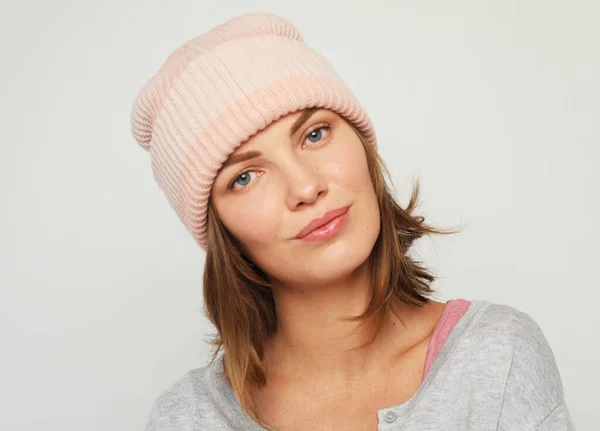 Young smiling blond woman wearing casual pink hat posing over grey background — Stock Photo, Image