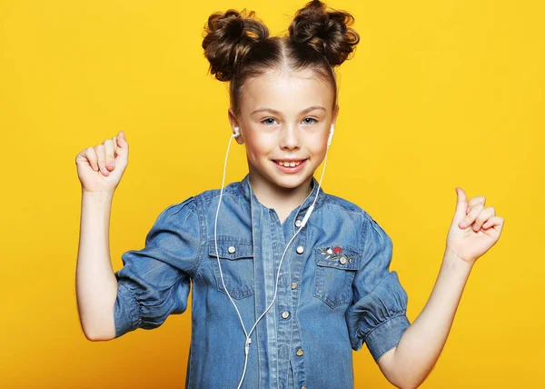 Emoção, infância, tehnologia e conceito de pessoas: menina feliz com fones de ouvido ouvindo música — Fotografia de Stock