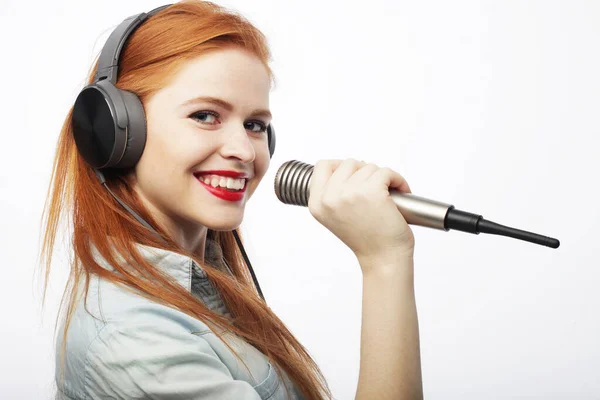 Młoda rudowłosa kobieta nosząca swobodny mikrofon na białym tle. — Zdjęcie stockowe