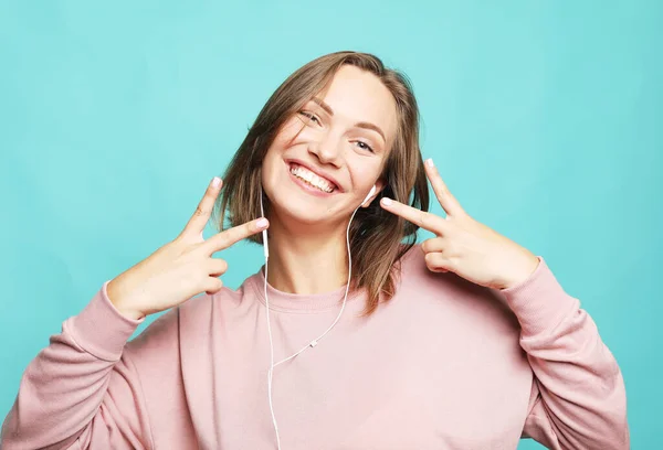 Retrato de uma jovem mulher loira feliz mostrando gesto de vitória e piscando, tiro estúdio. — Fotografia de Stock