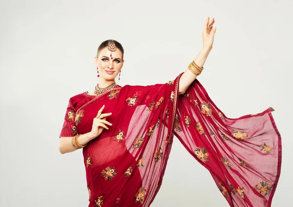 indian woman in traditional clothing dancing over grey background