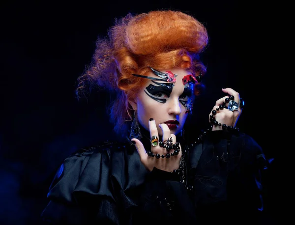 Strega gotica. Foto di Halloween. Donna dai capelli rossi con trucco luminoso. — Foto Stock