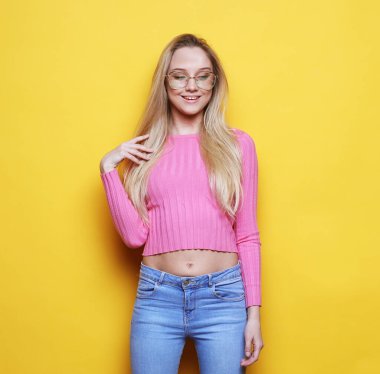 Genç ve neşeli sarışın kadın kameraya bakıp gülümsüyor ve gülüyor.