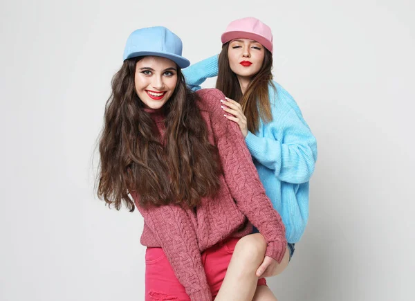 Yaşam tarzı ve insan konsepti: İki genç kız arkadaş süveter giyiyor ve birlikte duruyor ve eğleniyorlar. — Stok fotoğraf