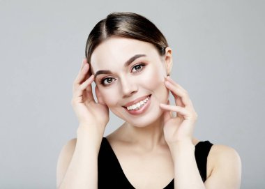 Gri arka planda mükemmel makyajı olan güzel bir kadın. Güzellik ve cilt bakımı. Kapat..