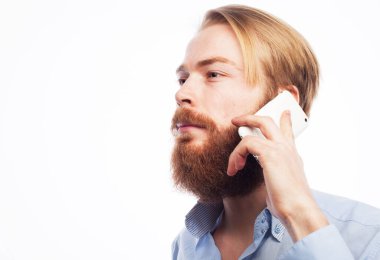 İş, insan ve tehnoloji kavramı: genç mutlu sakallı adam beyaz arka planda cep telefonuyla konuşuyor
