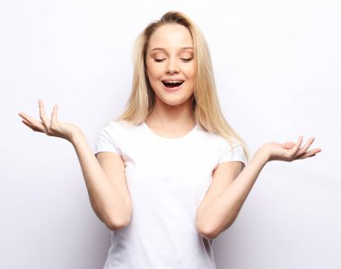 Yaşam tarzı ve insan konsepti. Güzel bir kız sana şaşırmış ve şok olmuş görünüyor. Ürününüzü sunuyorum. Etkileyici yüz ifadeleri. Stüdyo çekimi.