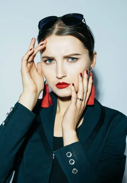 Mujer morena de moda posando en look moderno. Chaqueta negra, traje de baño negro, gafas de sol y pendientes rojos. — Foto de Stock