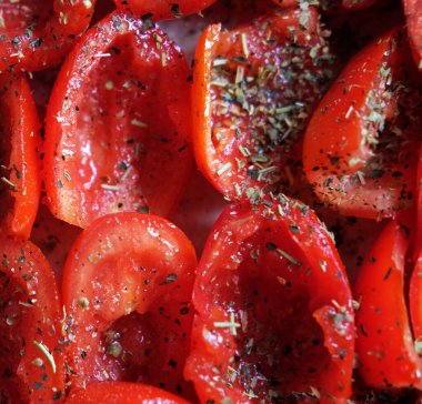 Domatesler fırın tepsisine konmuş, pişirmeye hazır. Güneşte kurutulmuş domates. Kapat..