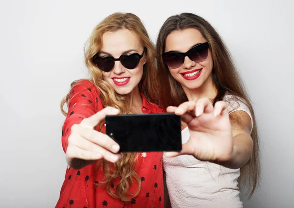 Dos mujeres jóvenes felices con teléfono inteligente —  Fotos de Stock