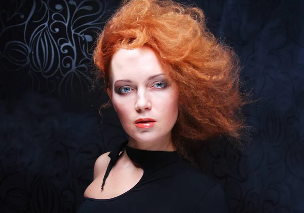 Portret van mooie mode vrouw model met elegantie make-up en krullend rood haar over donkere achtergrond. — Stockfoto