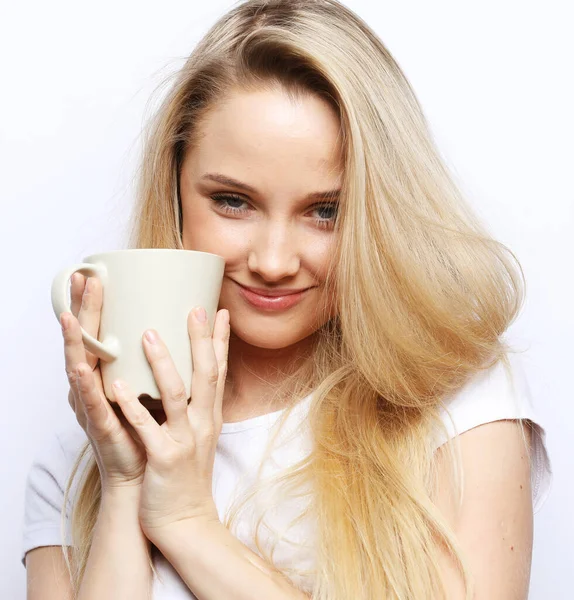 Молода блондинка тримає білу чашку. Красива дівчина з довгим білим волоссям тримає чашку з чаєм . — стокове фото