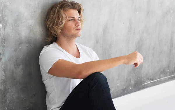 Handsome young male model sitting on the floor
