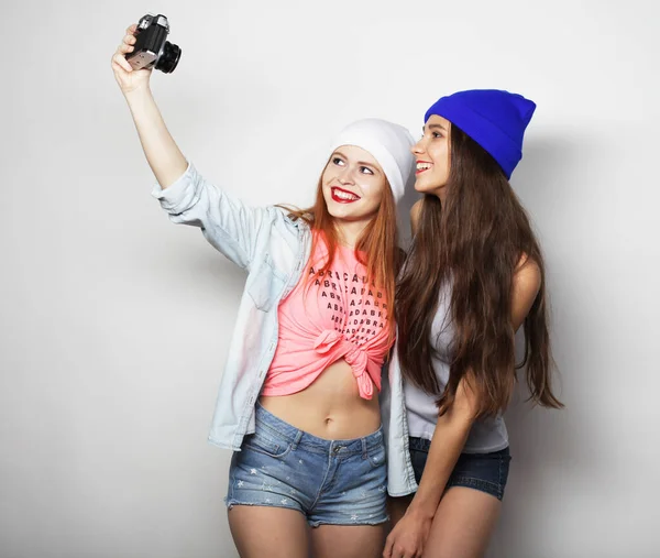 Lifestyle, friendship, emotion and people concept: Happy girls friends taking some pictures witn vintage camera — Stock Photo, Image