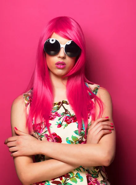 有粉色头发和粉色背景的大太阳镜的年轻时髦女人 — 图库照片