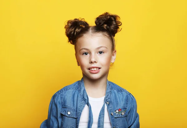 Портрет веселой улыбающейся маленькой девочки на желтом фоне — стоковое фото