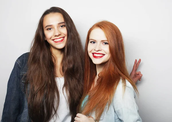 Estilo de vida, emoción y concepto de la gente: Dos amigas jóvenes de pie juntas y divirtiéndose. — Foto de Stock