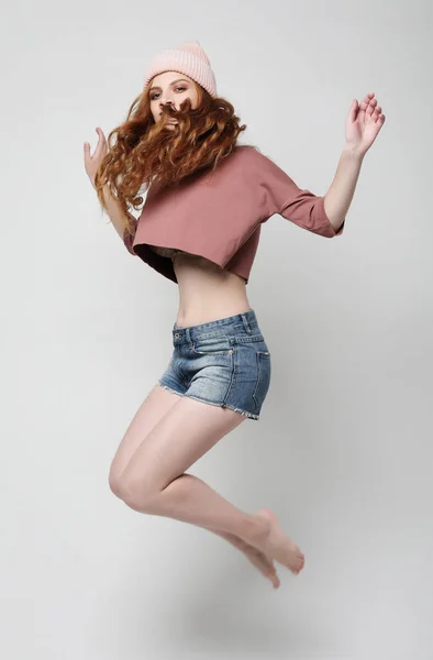 Plná délka portrét radostné mladé ženy skákání přes šedé pozadí — Stock fotografie