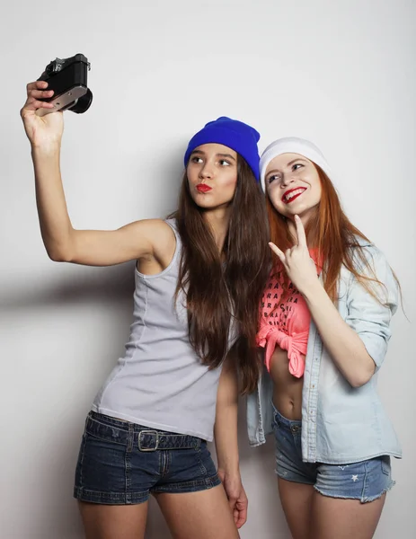 Styl życia, przyjaźń, emocje i koncepcja ludzi: Happy girls friends taking some photos witn vintage camera — Zdjęcie stockowe