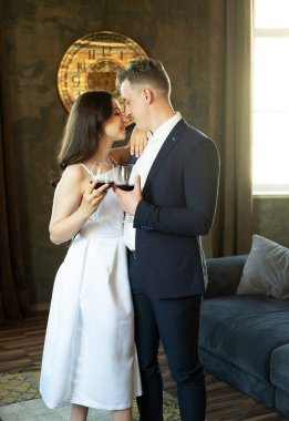 Yeni evli çiftimiz şarap içip mutluluklarına gülümsüyor.