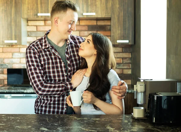 Jovem casal encantador feliz tomar café da manhã no início da manhã em casa, abraço, sorriso. — Fotografia de Stock