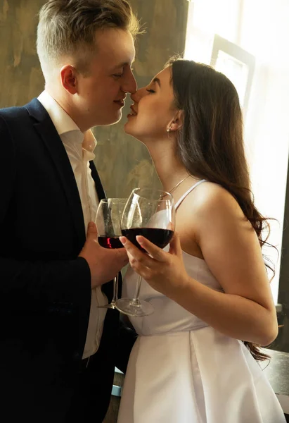 Jovem casal recém-casado bebendo vinho e sorrindo para sua felicidade, romance e ternura — Fotografia de Stock