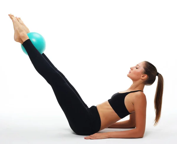 Giovane donna adulta in forma che fa esercizio di yoga allenamento con la palla ginnastica. — Foto Stock
