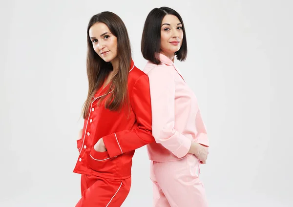 Two beautiful girlfriends dressed in pajamas pose for the camera. — Stock Photo, Image