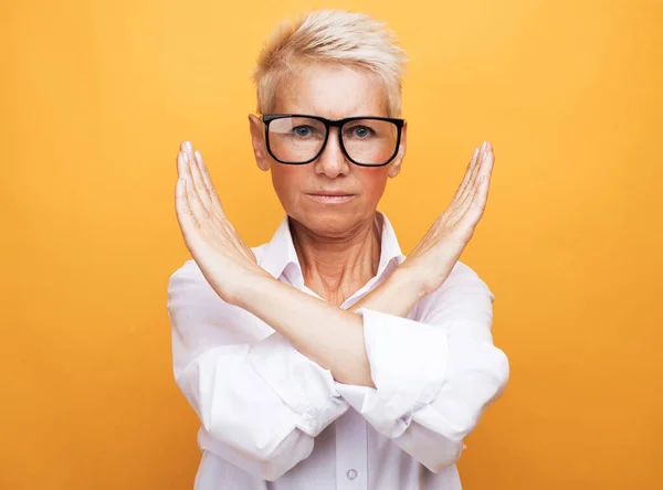 Senior woman rejection expression crossing arms doing negative sign — Stock Photo, Image