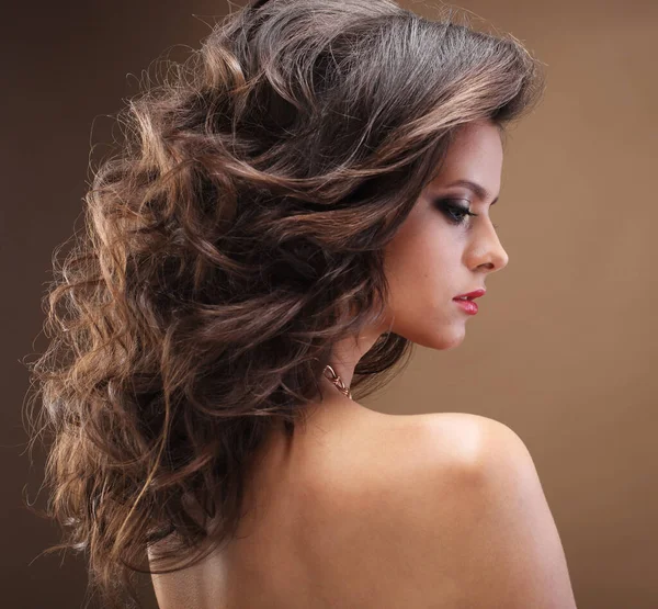 Menina morena com cabelo encaracolado longo, saudável e brilhante. Mulher modelo bonita com penteado ondulado .Care e beleza. — Fotografia de Stock