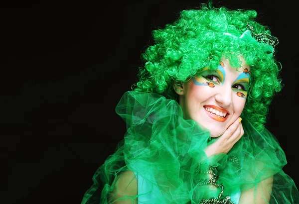 Mujer joven con linda sonrisa con rostro creativo y peluca verde sobre fondo negro. —  Fotos de Stock