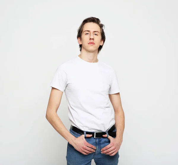 Yaşam tarzı, moda, duygu ve insan konsepti: Genç adam beyaz arka planda beyaz tişört giyiyor — Stok fotoğraf