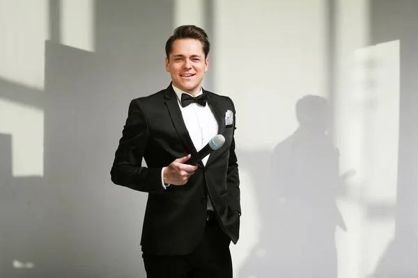 Young Showman presenter with microphone against white background. Showman concept. — Stock Photo, Image