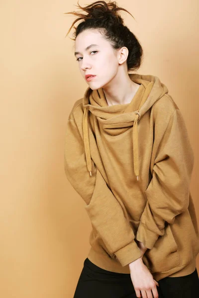 Joven morena modelo posando sobre fondo beige. — Foto de Stock