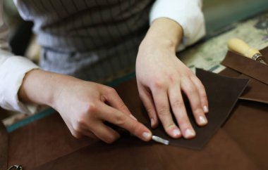 Eski bir atölyede çalışan deri çantalı bir zanaatkar. Küçük işletme kavramı.