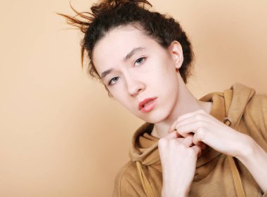 Bej arka planda poz veren esmer kadın model..