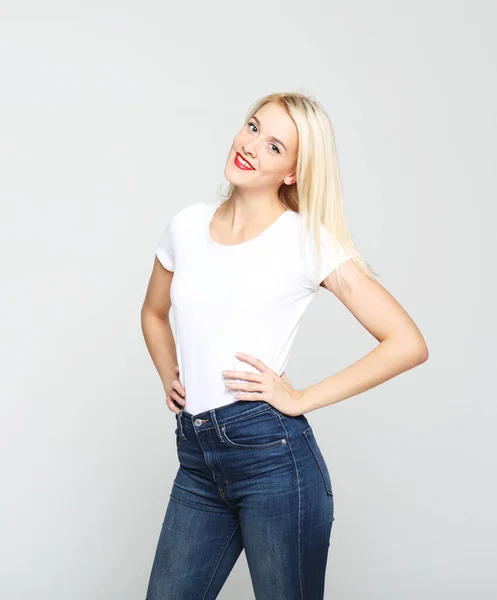 Young woman wearing casual clothes, posing on grey background — Stock Photo, Image