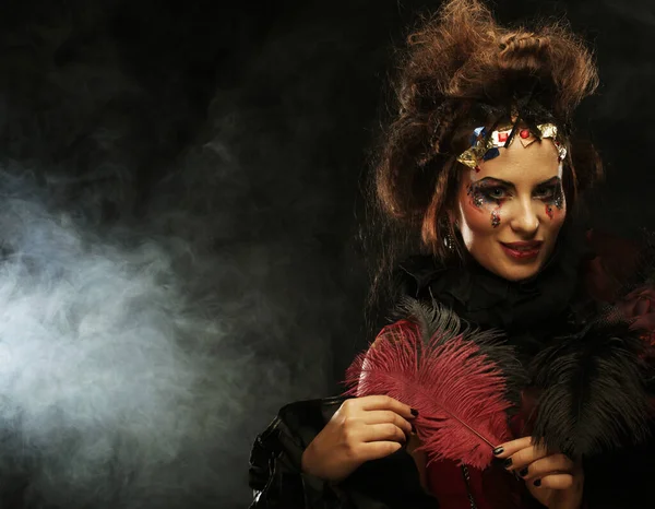 Giovane donna alla moda con trucco creativo e acconciatura in posa su sfondo scuro. — Foto Stock