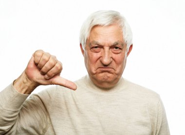 Tecrit edilmiş beyaz arka planda duran yaşlı adam mutsuz ve kızgın görünüyor. Reddedilmiş ve olumsuz..