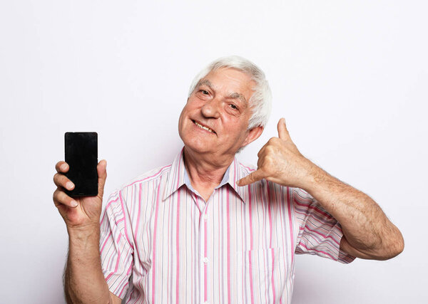 old man using smartphone and show call me desture over white background.