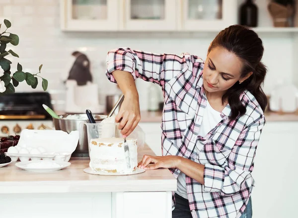 Életmód, főzés és szabadúszó koncepció: Gyönyörű fiatal nő krém torta rétegek. — Stock Fotó