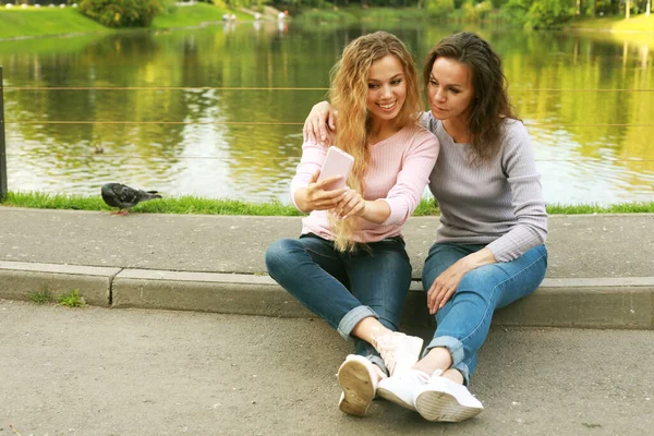 Lifestyle, family and people concept - Μητέρα με ενήλικη κόρη στο πάρκο μαζί — Φωτογραφία Αρχείου