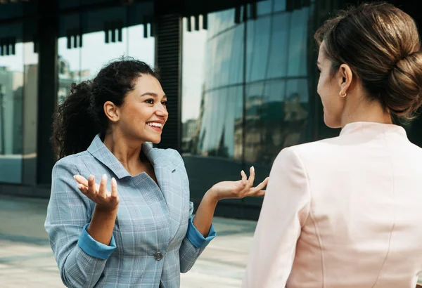 Business, people and lifestyle concept: Two business women having a casual meeting or discussion near a modern office — Stock Photo, Image