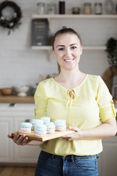 Young baker woman holding marshmallow. Happy, smiling and cheerful. — Stock Photo, Image