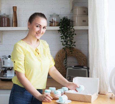 Genç fırıncı kadın lokum tutuyor. Mutlu, gülümseyen ve neşeli.