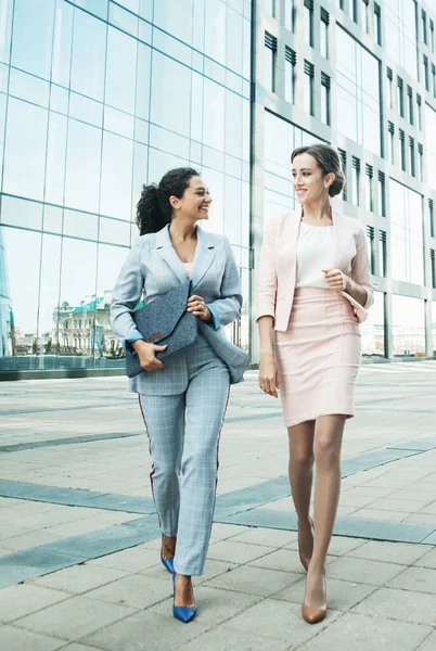 Business, people and lifestyle concept: two office workers standing together outdors near modern business building. — Stock Photo, Image