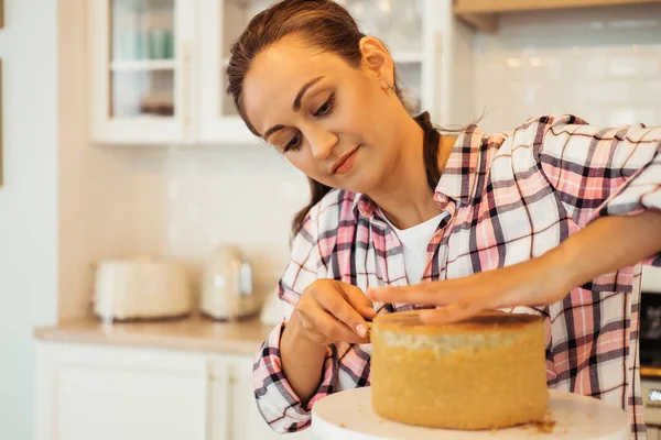 Lifestyle, cooking and freelance concept: Beautiful young woman cuts cake cakes with a knife. — Stock Photo, Image