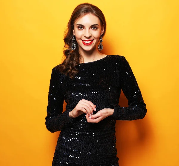 Mulher morena caucasiana elegante com penteado encaracolado. Menina de aniversário encantadora em vestido de brilho em pé em pose confiante. — Fotografia de Stock