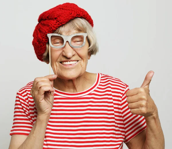 Lifestyle, emotion and people concept: funny grandmother with fake glasses, laughs and ready for party — Stock Photo, Image