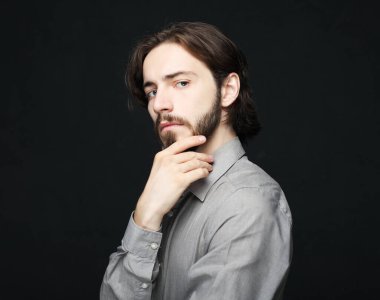 Mutsuz adam siyah arka planda alnına dokunuyor.